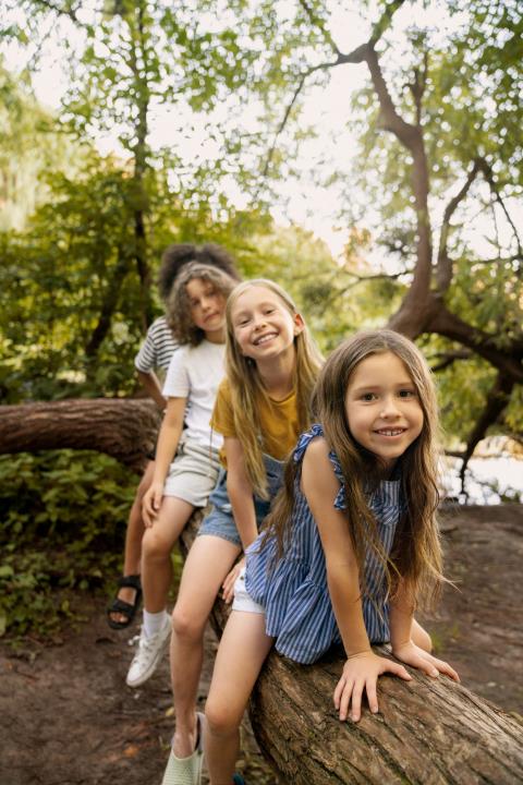 camp_full-shot-smiley-kids-sitting-log.jpg